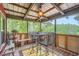 Inviting screened-in porch with rustic decor, a dining set, and a peaceful view of the surrounding woods at 5419 Tyree Rd, Winston, GA 30187