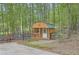 Exterior view of a charming wooden shed with a porch, situated among the trees at 5419 Tyree Rd, Winston, GA 30187