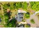 Bird's-eye view of the property showing the back deck, lush greenery, circular drive, and surrounding landscape at 7048 Bennington Ln, Cumming, GA 30041
