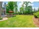 Beautiful backyard with a lush lawn, deck, and mature trees; perfect for outdoor enjoyment at 7048 Bennington Ln, Cumming, GA 30041