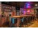 Custom bar with rustic wood details, decorative lighting, exposed brick, and unique decor at 7048 Bennington Ln, Cumming, GA 30041