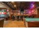 Basement with a stylish bar area, featuring exposed brick, unique decor, and a billiards table at 7048 Bennington Ln, Cumming, GA 30041