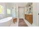 Bathroom featuring a freestanding tub, glass shower, wood vanity, and marble floors at 7048 Bennington Ln, Cumming, GA 30041