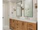 Bathroom featuring wood cabinets, marble countertops, and tiled walls at 7048 Bennington Ln, Cumming, GA 30041