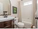 Cozy bathroom featuring a shower-tub combo with updated fixtures and a wooden vanity at 7048 Bennington Ln, Cumming, GA 30041