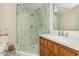 Bathroom featuring a glass enclosed shower with vertically stacked tile, natural wood vanity, and quartz countertop at 7048 Bennington Ln, Cumming, GA 30041