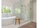 Bathroom featuring a freestanding tub, glass shower, and marble floors at 7048 Bennington Ln, Cumming, GA 30041