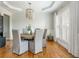 Bright dining room with a beaded chandelier, light gray chairs, and elegant window treatments at 7048 Bennington Ln, Cumming, GA 30041