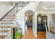 Inviting foyer with hardwood floors, staircase with iron railing, and views into the living room at 7048 Bennington Ln, Cumming, GA 30041