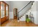 Elegant foyer with hardwood floors, staircase with iron railing, and natural light streaming through glass doors at 7048 Bennington Ln, Cumming, GA 30041