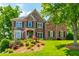 Beautiful two-story brick home boasts lush landscaping, an inviting entrance, and a well-manicured lawn at 7048 Bennington Ln, Cumming, GA 30041