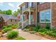 Charming brick home with a welcoming front porch, complete with an American flag and lush landscaping at 7048 Bennington Ln, Cumming, GA 30041