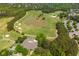 Aerial view of a stunning golf course featuring a water hazard and a modern clubhouse at 7048 Bennington Ln, Cumming, GA 30041