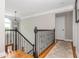 Upstairs hallway with hardwood floors, an ornate black railing, and neutral wall paint at 7048 Bennington Ln, Cumming, GA 30041