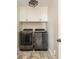 Functional laundry room featuring modern front loading washer and dryer with white cabinetry at 7048 Bennington Ln, Cumming, GA 30041