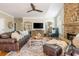Spacious living room with a stone fireplace, hardwood floors, and a large leather couch at 7048 Bennington Ln, Cumming, GA 30041