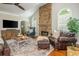 Cozy living room with a stone fireplace, hardwood floors, and ample seating at 7048 Bennington Ln, Cumming, GA 30041