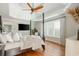 Bedroom featuring hardwood floors, tray ceiling, large windows, and a mounted television at 7048 Bennington Ln, Cumming, GA 30041
