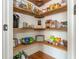 Walk-in pantry with wooden shelves stocked with a variety of food items at 7048 Bennington Ln, Cumming, GA 30041