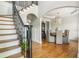 Staircase with iron railings leads to a dining area featuring a chandelier and neutral-toned furniture at 7048 Bennington Ln, Cumming, GA 30041