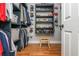 Neatly organized walk-in closet with custom shelving for hats and shoes and rods for clothing at 7048 Bennington Ln, Cumming, GA 30041