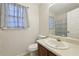 Cozy bathroom featuring a vanity with sink and a toilet, complemented by patterned curtains at 1031 Bettina Sw Ct, Mableton, GA 30126