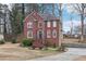 Charming two-story red brick home with manicured front yard landscaping on a sunny day at 1031 Bettina Sw Ct, Mableton, GA 30126
