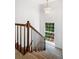 Well-lit staircase with wood railing and modern chandelier, offering views to the outside at 1229 Colony Cir, Marietta, GA 30068