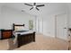 Neutral bedroom featuring a dark wood bed frame, matching nightstand, ceiling fan, and natural light at 2265 Venture Dr, Marietta, GA 30062