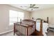 Bright bedroom with a dark wood crib and bed, a ceiling fan, and a large window at 314 Meadows Ln, Canton, GA 30114