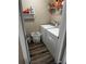Efficient laundry room featuring white washer and dryer, wood-look flooring, and shelving for supplies at 314 Meadows Ln, Canton, GA 30114