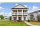 Charming two-story home featuring a welcoming front porch, manicured lawn, and beautiful landscaping at 4724 Electric Sw Ave, Mableton, GA 30126