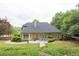 Extensive backyard with lush landscaping, mature trees, and a quaint patio area at 1720 Ivey Trce, Cumming, GA 30041