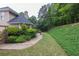 Well maintained backyard with stone patio, lush landscaping, and a serene wooded backdrop at 1720 Ivey Trce, Cumming, GA 30041