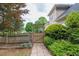 Landscaped backyard with a wooden fence, lush bushes, and stone walkway at 1720 Ivey Trce, Cumming, GA 30041