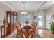 Dining room featuring a wooden table set with carved chairs, hardwood floors, and a decorative light fixture at 1720 Ivey Trce, Cumming, GA 30041
