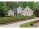 Attractive tan home with a dark roof, showcasing a meticulously maintained front yard with shrubbery at 1720 Ivey Trce, Cumming, GA 30041