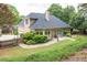 Exterior view showing an immaculate lawn, manicured shrubs, and a private patio at 1720 Ivey Trce, Cumming, GA 30041