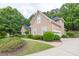 Side view of a two-story tan home, highlighting the attached garage and mature greenery at 1720 Ivey Trce, Cumming, GA 30041