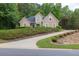 Lovely tan home with a curved driveway, lush landscaping, and a meticulously maintained front yard at 1720 Ivey Trce, Cumming, GA 30041