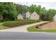 Well-maintained tan home with a curved driveway, mature trees, and meticulously arranged landscaping at 1720 Ivey Trce, Cumming, GA 30041
