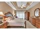 Luxurious main bedroom with tray ceiling, ceiling fan, and elegant furniture at 1720 Ivey Trce, Cumming, GA 30041