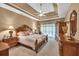 Elegant main bedroom with tray ceiling, ceiling fan, and ample natural light at 1720 Ivey Trce, Cumming, GA 30041