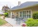 Charming outdoor patio with a glass table and chairs surrounded by landscaped greenery at 1720 Ivey Trce, Cumming, GA 30041
