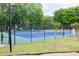 Well-maintained tennis court for residents, surrounded by trees at 1720 Ivey Trce, Cumming, GA 30041