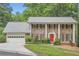 Traditional brick home with a red front door, white columns, and a well-manicured lawn at 2034 Starfire Ne Dr, Atlanta, GA 30345