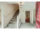 Inviting foyer with stairs, tile flooring, and an open doorway, adjacent to the red front door at 2034 Starfire Ne Dr, Atlanta, GA 30345