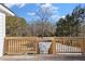 View of the backyard, featuring mature trees and steps down from the wooden deck at 4064 Post Rd, Winston, GA 30187