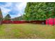 Backyard featuring a well-maintained lawn, a red shed, and a wooden fence at 10892 Big Sky Dr, Hampton, GA 30228