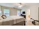 Bright bedroom featuring a ceiling fan, two windows, and doorway to an ensuite bathroom at 10892 Big Sky Dr, Hampton, GA 30228